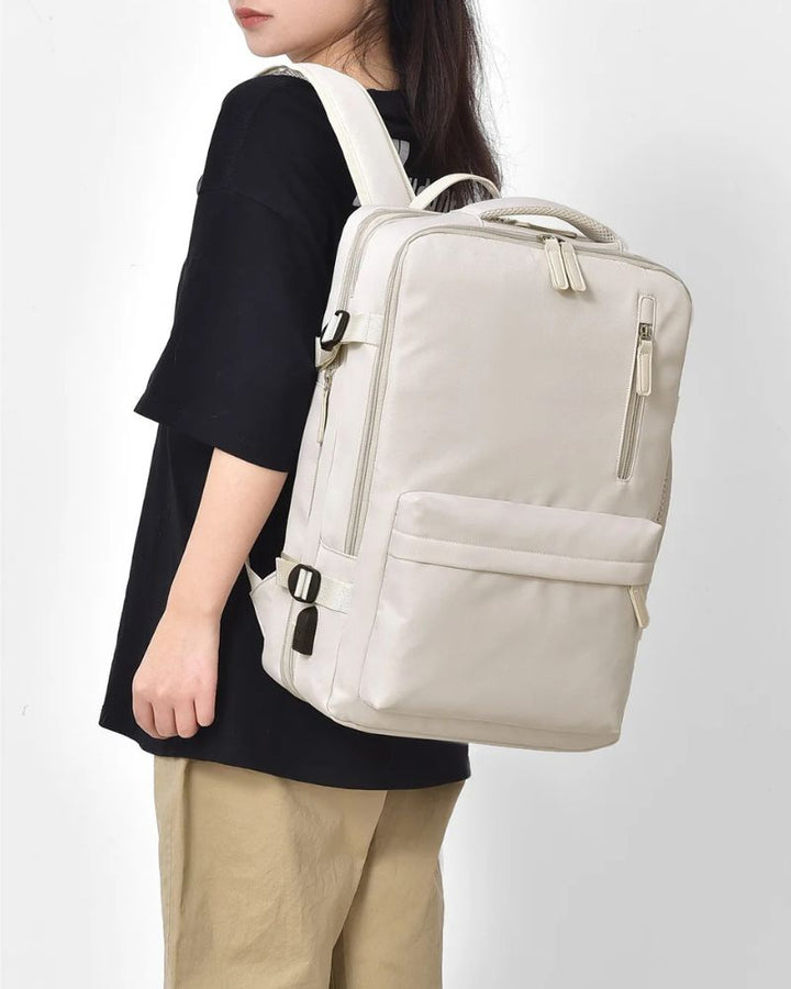 Sac à dos cabine extensible, coloris crème porté sur l'épaule