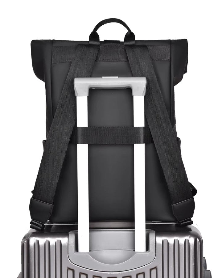 Vue arrière du sac à dos urbain attaché à une valise, montrant la sangle trolley et les bretelles rembourrées.