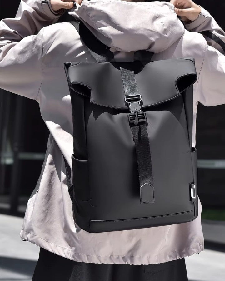 Modèle portant un petit sac à dos noir en ville, illustrant la taille compacte et la sobriété du design.