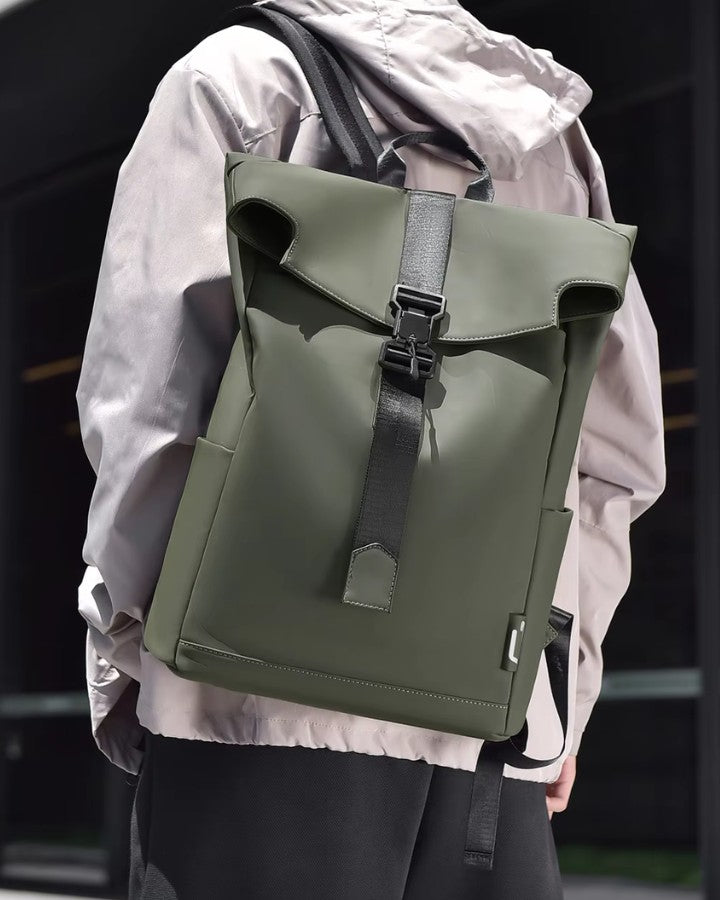Homme portant un petit sac à dos de ville vert kaki pour homme, avec design minimaliste et sangle frontale.