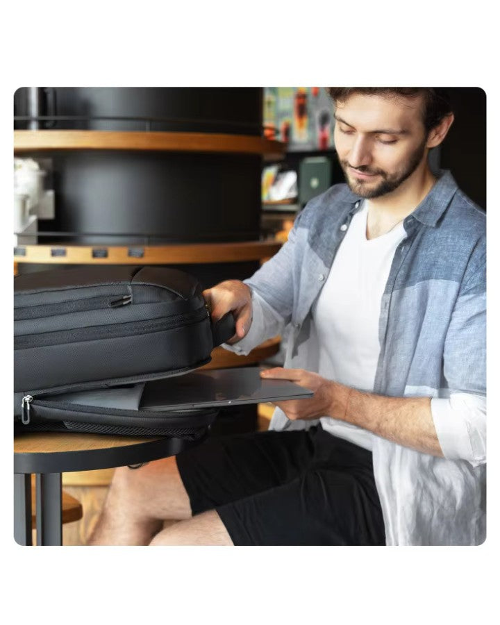 Homme glissant un ordinateur portable 15,6 pouces dans le compartiment dédié du sac à dos 40 × 30 × 15 cm.