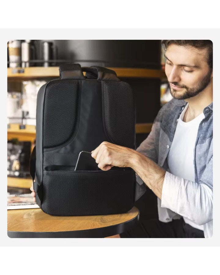 Homme rangeant son téléphone dans la poche arrière sécurisée du sac à dos, illustrant l’accès pratique.