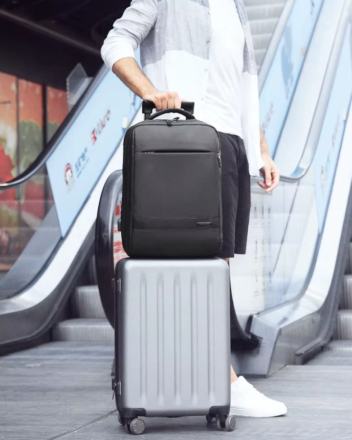 Sac à dos fixé sur une valise grâce à la sangle trolley, prêt pour un voyage.