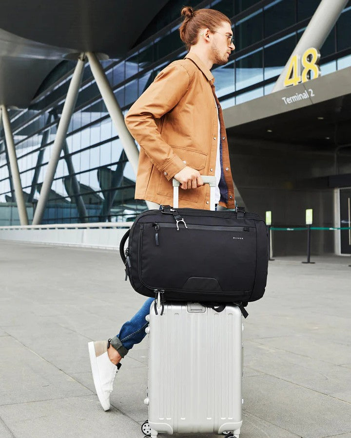 Sac à Dos Cabine 55 x 35 x 25 cm, fixé sur une valise à roulette, tirer par un homme