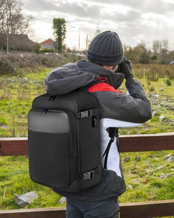 Sac à Dos Cabine Avion 40x20x25, porté sur le dos d'un homme, en train de prendre une photo avec un appareil photo