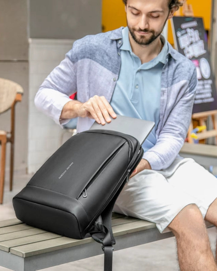 Photo d’un homme insérant un ordinateur portable dans le sac à dos léger lors d’un usage quotidien.