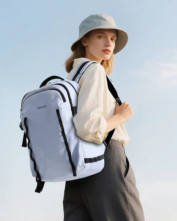 Femme portant un sac à dos de voyage et ordinateur bleu clair, design moderne et minimaliste