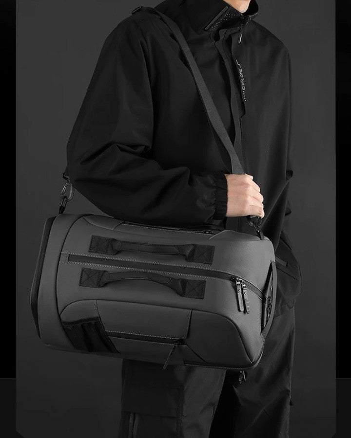 Sac Bandoulière Transformable en Sac à Dos, gris foncé, porté en bandoulière sur l'épaule d'un homme